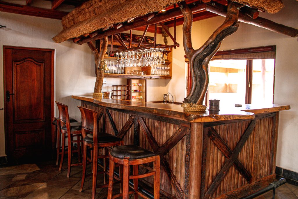 Wooden bar with bar stools and a thatch roofing
